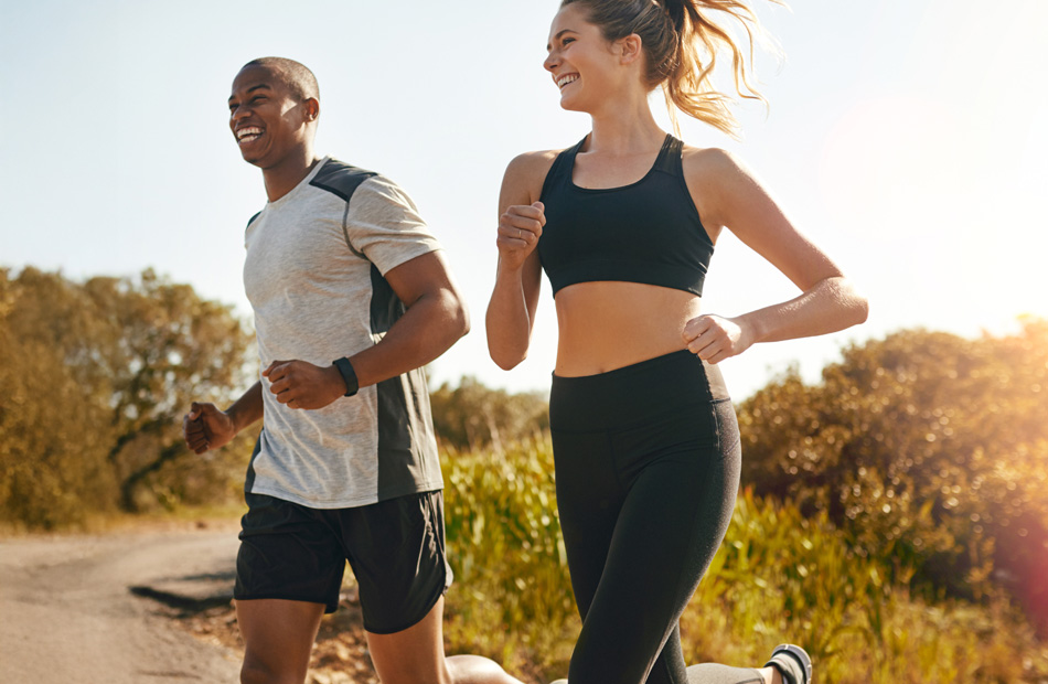 Two people jogging outdoors on trail