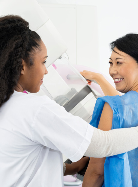 Technologist assisting patient during mammogram exam