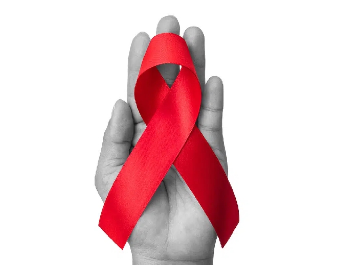 Red awareness ribbon held in hand